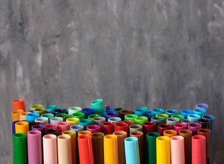 A set of colorful markers, with a place for copy space on grey background