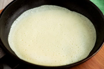 The process of baking pancake. The dough for pancakes in a pan. Baking thin pancake in a pan.