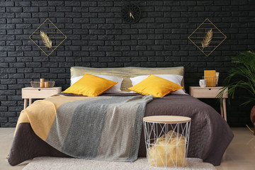 Big bed in interior of room with golden decor