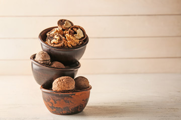 Bowls with tasty walnuts on white table