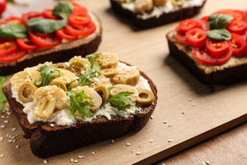 Fresh tasty bruschettas on wooden board, closeup