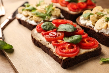 Fresh tasty bruschettas on wooden board, closeup