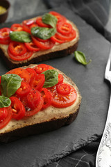 Fresh tasty bruschettas on slate plate, closeup