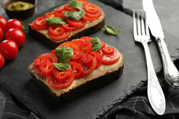Fresh tasty bruschettas on slate plate, closeup