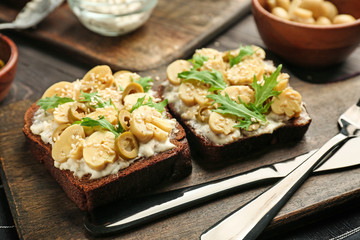 Fresh tasty bruschettas on wooden board, closeup