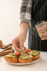 Woman preparing tasty bruschettas