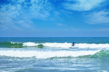 Fototapeta na wymiar Surfing. A surfer catches a ocean wave. Man on surfboard