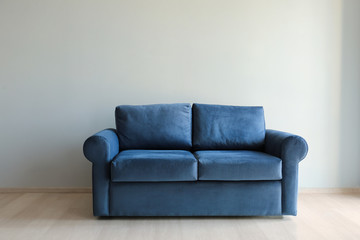 Comfortable sofa near light wall