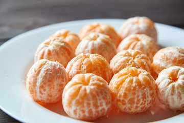 Whole peeled tangerine fruits on plate