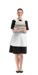 Portrait of beautiful female housekeeper with clean towels on white background