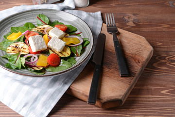 Healthy salad with feta cheese on wooden table