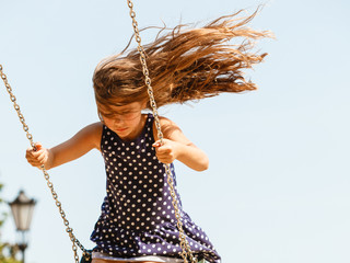 Girl swinging on swing-set.