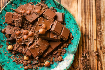 Plate with tasty chocolate on wooden background