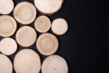 Pine tree cross-sections with annual rings on black background. Lumber piece close-up shot, top view.
