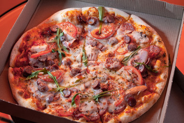  Round tasty pizza in a cardboard box with home delivery.