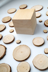 Pine tree cross-sections with annual rings and wooden cube on white background. Lumber piece close-up shot.