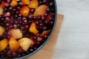 Boiled fruits and berries in a saucepan. View from above. Healthy food in the form of juice from apples and berries. Prepare a sweet drink from fruits and berries.