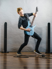 Young man playing electric guitar