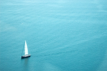 sailboat in vast blue open ocean lots of copy space