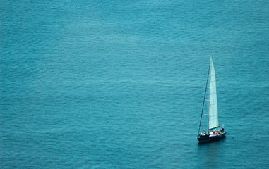 sailboat in vast blue open ocean on an adventure
