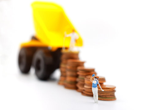 Miniature people: Golfers hit golf balls up to the top coins,  Finance, investment and growth in business concept.