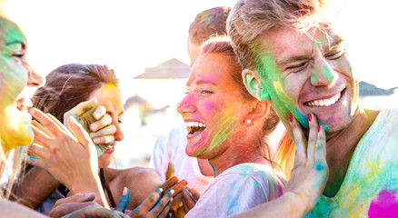 Happy friends having fun at beach party on holi colors festival event - Young people laughing...