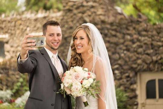 Young attractive bride and groom taking a selfie