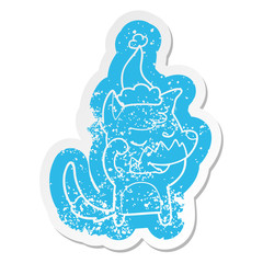 friendly cartoon distressed sticker of a fox waking up wearing santa hat