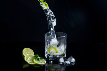 Summer cocktail mojito with splash on black background..
