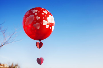 A little girl with red balloon on the blue sky.