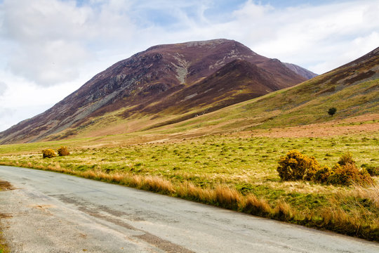 A lane running through moorland and livestock pastures in Lake District, Cumbria, England, UK