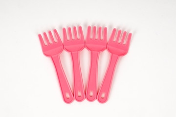 Pink plastic baby fork on a white background isolated