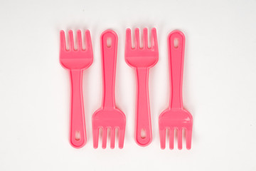 Pink plastic baby fork on a white background isolated