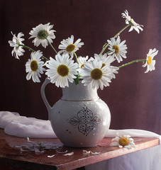 Still life with a bouquet of daisies on a wooden background