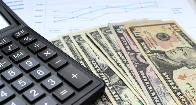 close up calculator and dollar on office desk, financial concept.