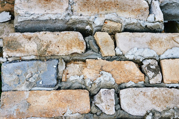 Rows of gray yellow bricks in concrete masonry with a solid old background close-up.