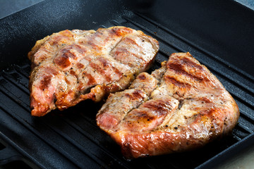 Two Grilled beef steaks on grill pan.
