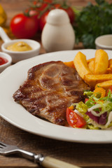 Grilled pork neck served with French fries and salad.