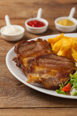 Grilled pork neck served with French fries and salad.