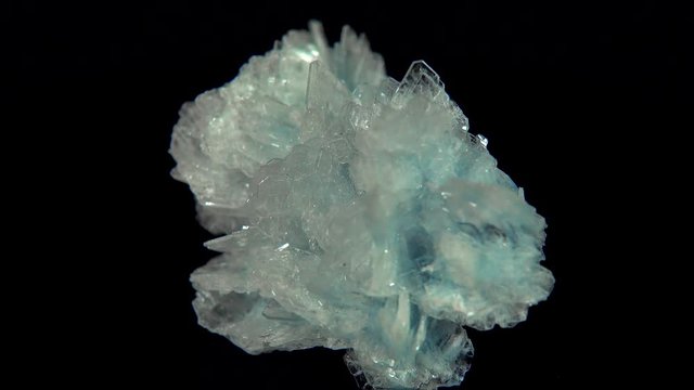 Seamlessly rotating a light blue mineral (Baryte) in front of black background