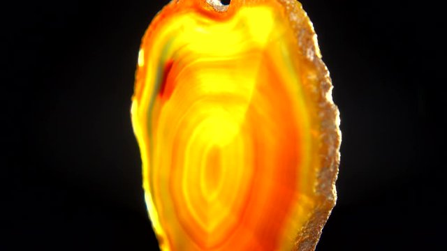 Seamlessly rotating an orange mineral (Orange Agate) in front of black background