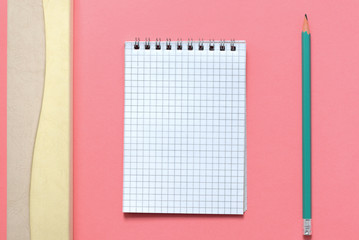 Blank notepad, pencil-box and pencil on pink background close up