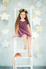 Portrait of a beautiful blue-eyed girl, little sitting on a chair. Spring break, Mother's Day, Women's Day.