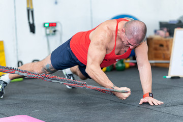 Revoring at trx. Strong man making exercises at gym