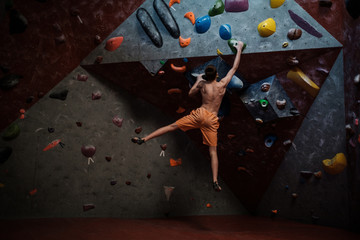 Athletic man practicing in a bouldering gym