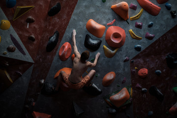Athletic man practicing in a bouldering gym