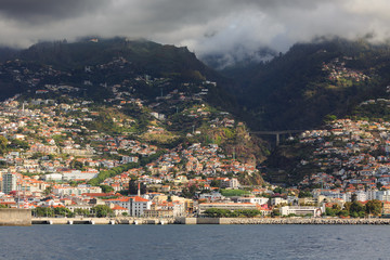 Fototapeta na wymiar Beautiful cityscape view of the city Funchal, Madeira, seen from the Atlantic ocean, with ominous clouds