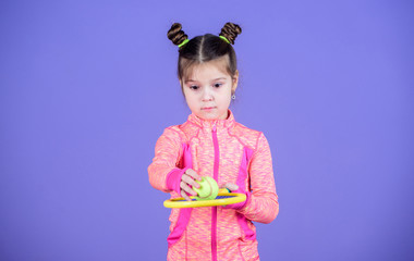 Small cutie likes tennis. Little baby sporty costume play tennis game. Teach me how to play tennis. Girl cute child double bun hairstyle tennis player. Childhood and active games. Sport upbringing