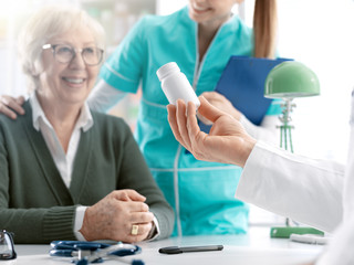 Professional doctor giving a prescription medicine to a senior patient