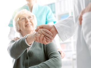 Doctor giving an handshake to a senior patient